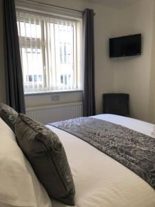 1 dormitorio con cama con almohadas y ventana en The Bell Hotel, en Newtown