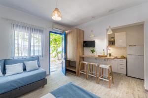 uma sala de estar com um sofá azul e uma cozinha em Blue Paradise em Lerápetra