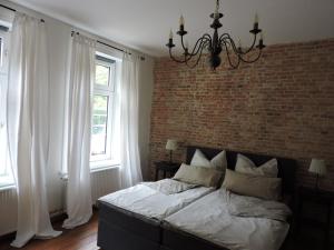 Un dormitorio con una pared de ladrillo y una cama en Altes Pastorat, en Barmstedt
