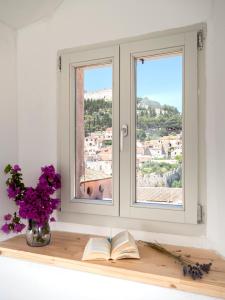 una ventana con un libro y flores en un estante en Velada Center en Hvar