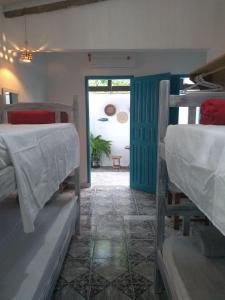 a room with two bunk beds and a doorway at Estação Caraíva in Caraíva