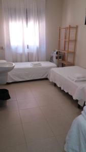 Habitación con 2 camas, lavabo y ventana en Residencial Oscense en Huesca