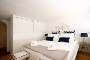 ein weißes Schlafzimmer mit einem großen weißen Bett mit blauen Kissen in der Unterkunft Loft 5c - Palatino in Rom