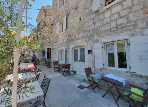 a patio with tables and chairs next to a building at Velada Center in Hvar