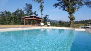 a swimming pool with a gazebo in the background at Agriturismo Ca' de' Magnani in Baragazza