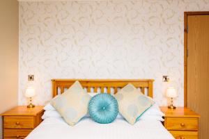a bed with a white comforter and two pillows at Elan Hotel in Rhayader