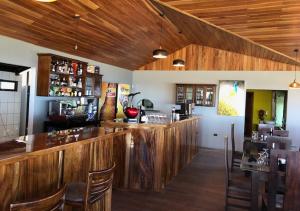 un bar en un restaurante con paredes de madera y suelo de madera en Hotel Trópico Monteverde en Monteverde