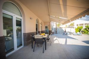 a patio with a table and chairs on a house at Villa Jandia Modern new apartment Morro Jable Private heated pool big terrace and parking in Morro del Jable