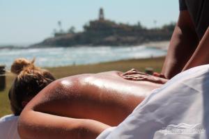 a woman laying on the beach with her back to the camera at Cerritos Surf Town - Beach Front Property in El Pescadero
