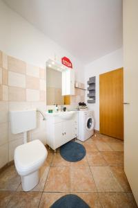 a bathroom with a toilet and a sink and a washing machine at Stomorica Apartments in Zadar +71 photos