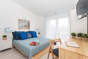 a bedroom with a bed with blue pillows and a desk at Arenda in Karwia