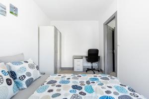 a bedroom with a bed with blue and white pillows at Comfort Stay Basel Airport 1B46 in Saint-Louis