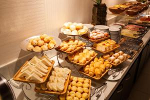 a buffet with many different types of food on a counter at Hotel D'Luca in Cuiabá