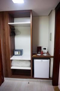 a kitchen with a refrigerator and a microwave at Hotel D'Luca in Cuiabá