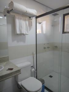a bathroom with a toilet, sink, and shower stall at Hotel D'Luca in Cuiabá