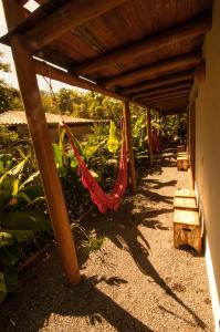 um pátio com uma rede de descanso sob uma pérgula de madeira em Casa de Paixão Caraíva em Caraíva