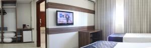 a hotel room with a television and a bed at Hotel D'Luca in Cuiabá +29 photos