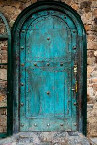 eine alte blaue Tür in einem Steingebäude in der Unterkunft IntiRumi Inn in Caraz