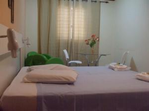 a bedroom with a bed and a table with chairs at Hotel Urubupunga in Ilha Solteira