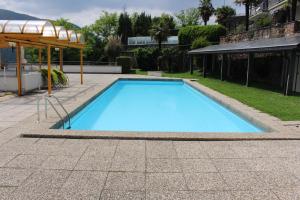 una gran piscina azul con sombrilla en Residenza Trivento app. 9, en Rovio