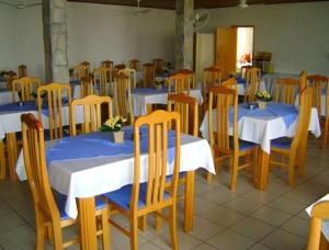 a dining room with tables and chairs with blue and white tablecloths at Hotel Urubupunga in Ilha Solteira
