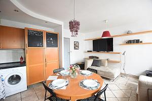 eine Küche und ein Wohnzimmer mit einem Tisch und einem Sofa in der Unterkunft Mhost Bronowice in Krakau