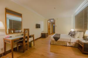 Cette chambre comprend un lit et un bureau. dans l'établissement Kingwood Hotel Sibu, à Sibu