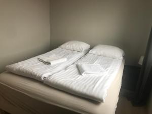 a bed with a white comforter and pillows at Guesthouse Skógafoss in Skogar