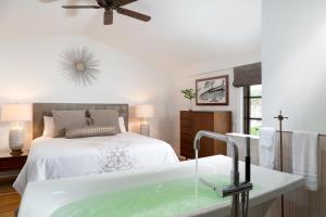 bagno con letto e vasca con lavandino di Black Dolphin Inn a New Smyrna Beach