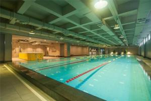 uma grande piscina num grande edifício em Green Park Hotel Tianjin em Binhai