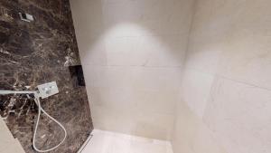 ein Bad mit einer Dusche und einer Steinmauer in der Unterkunft White Pearl Apartment 0.11 in Timmendorfer Strand + 24 Fotos