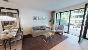 ein Wohnzimmer mit Sofa und Tisch in der Unterkunft White Pearl Apartment 0.11 in Timmendorfer Strand