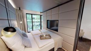 ティメンドルファー・シュトラントにあるWhite Pearl Apartment 1.10の鏡付きのベッドとテレビが備わる客室です。