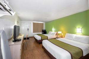 a hotel room with two beds and a flat screen tv at American Inn in Carlisle