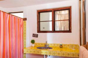 a bathroom with a sink and a window at Chillaxing Beach Front House in Tulum