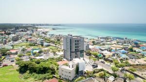 an aerial view of a city and the ocean at Lemain Hotel in Jeju