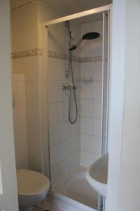 een badkamer met een douche, een toilet en een wastafel bij Kerstins Bed and Breakfast in Egmond aan Zee