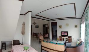 a living room and dining room with a table and chairs at Villa Oma Bougenville 2 in Puncak