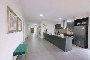 a large kitchen with a counter and a refrigerator at Luxury 9 BRM house in Melbourne in Laverton