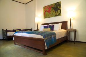 a bedroom with a large bed with two lamps at The Apsara in Luang Prabang