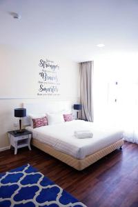 a bedroom with a large white bed and a blue rug at TY Hotel in Kuala Terengganu