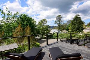 a balcony with two chairs and a view of trees at Cloudsong Chalet 1 Close to the village centre in Kangaroo Valley