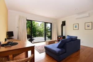 ein Wohnzimmer mit einem blauen Sofa und einem Tisch in der Unterkunft Cloudsong Chalet 1 Close to the village centre in Kangaroo Valley