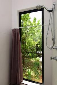 a shower curtain in a bathroom with a window at Cloudsong Chalet 2 Close to the village centre in Kangaroo Valley