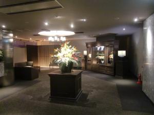 een lobby met een vaas met bloemen op een tafel bij Hotel GOLF Nirasaki (Adult Only) in Nirasaki