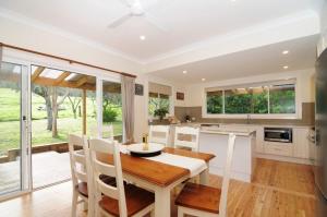 a kitchen and dining room with a table and chairs at Nellsville Cottage Kangaroo Valley in Upper Kangaroo River