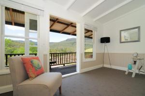 uma sala de estar com uma cadeira e uma varanda em Spring Grove Dairy Picturesque views em Upper Kangaroo River