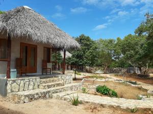 a house with a straw roof and stairs to a yard at Mulia Bungalows in Nembrala +26 photos