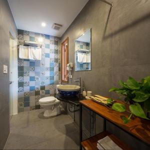 a bathroom with a toilet and a sink at Centraltique Downtown - Bespoke Colonial House Near Hoan Kiem Lake in Hanoi