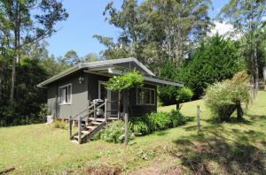 a tiny house in a field with a yard at Love Shack 1 bedroom cosy cottage in Upper Kangaroo River